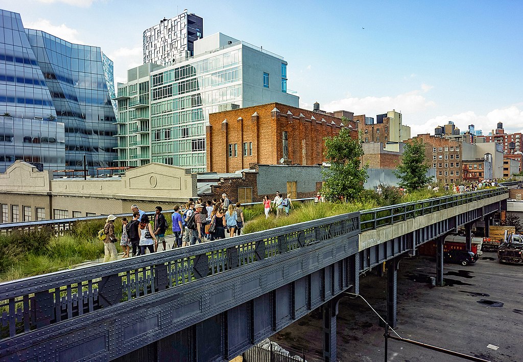 Visitors stroll the first section of the High Line Park, over the 18th Street crossing. Frank Gehry's IAC building is in the background.